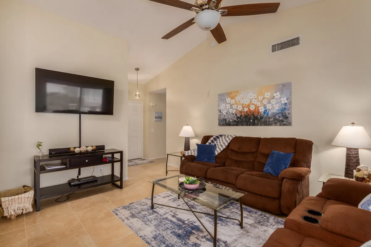 A cozy living space featuring a plush sofa, a coffee table, and a large television as the focal point, accented by tasteful artwork. This area is tailored for watching movies, relaxing, or hosting informal gatherings.