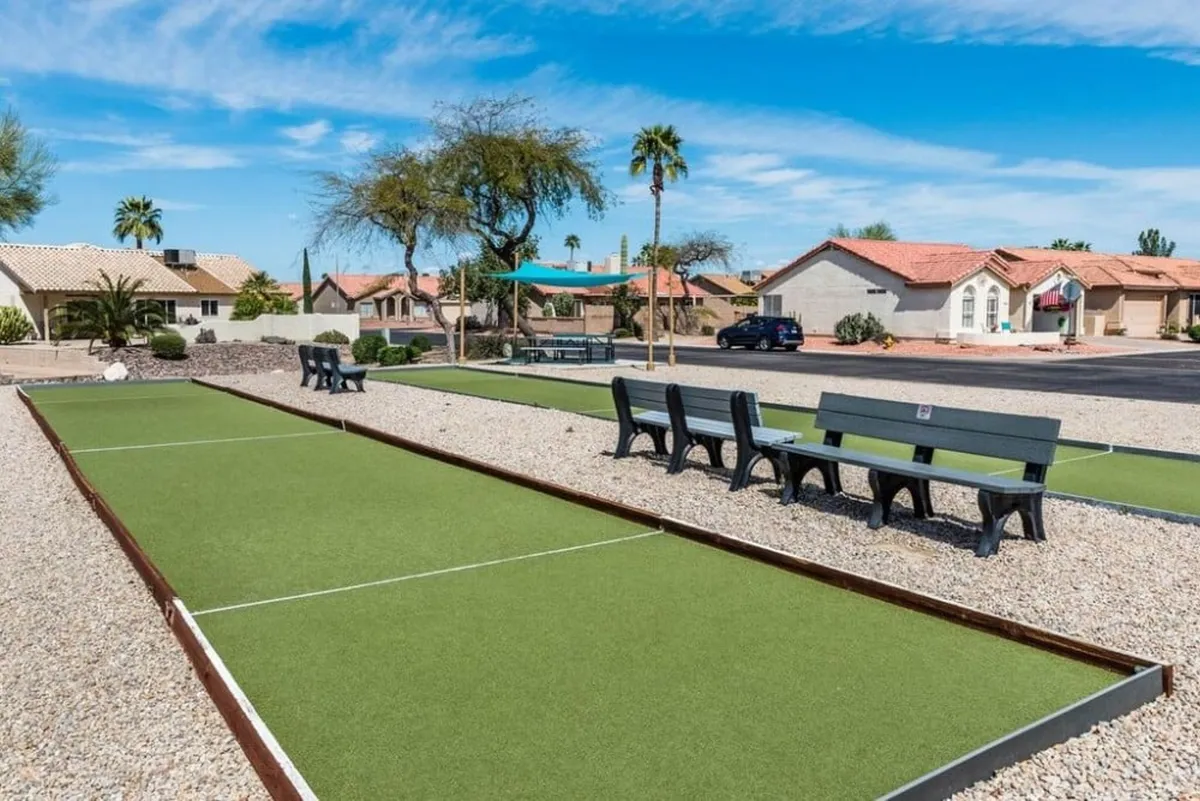 The exterior bocce ball court is surrounded by benches and attractive landscaping, inviting residents and guests to participate in friendly competitions and community events. The open setting encourages casual play and socializing among neighbors.